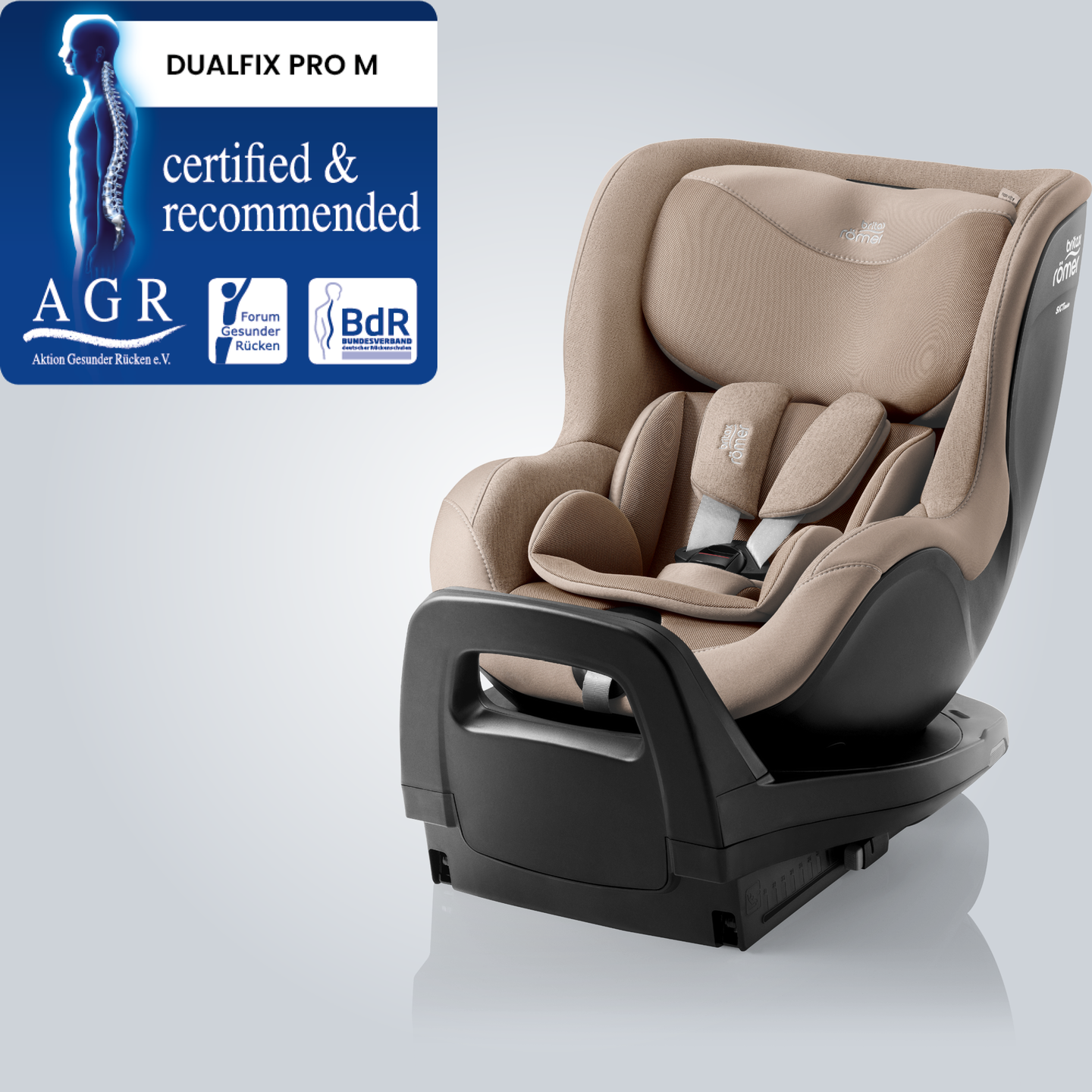 DUALFIX PRO M en Teak, asiento de coche giratorio 360&deg; para ni&ntilde;os peque&ntilde;os con reposacabezas y arn&eacute;s ajustables, mostrado en vista frontal angular con la insignia &ldquo;Tested & Recommended&rdquo; de Aktion Gesunder R&uuml;cken e.V.
